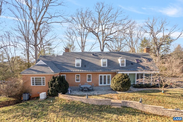 view of front of property with french doors, a chimney, a patio, and a front yard