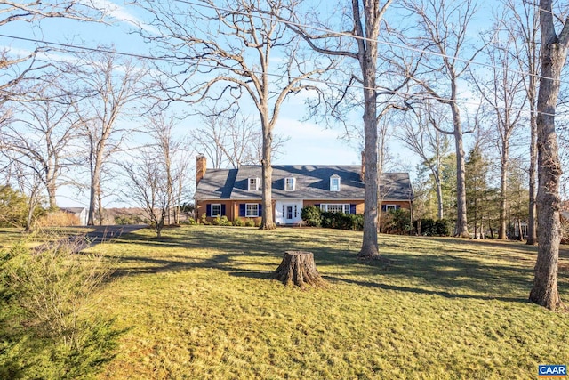 new england style home with a chimney and a front yard