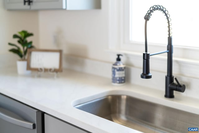 details with stainless steel dishwasher, sink, and white cabinetry