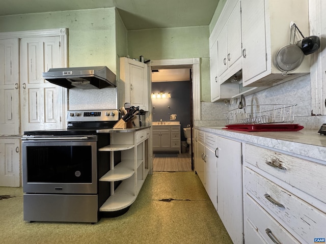 kitchen featuring under cabinet range hood, stainless steel electric range oven, white cabinetry, light countertops, and light floors