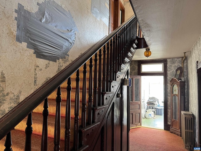 stairway featuring carpet and wallpapered walls