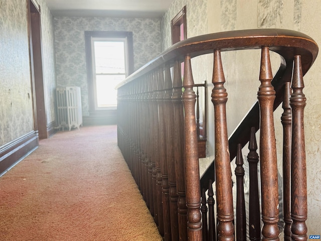hallway featuring radiator heating unit, baseboards, wallpapered walls, and carpet floors
