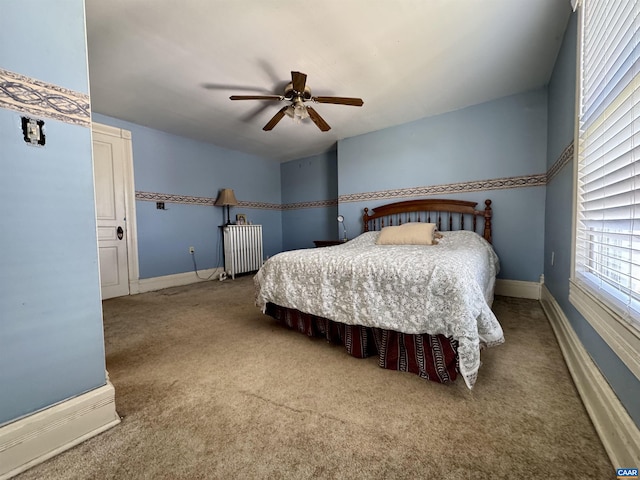 carpeted bedroom with baseboards, radiator heating unit, and ceiling fan