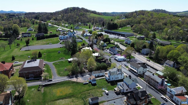 drone / aerial view with a wooded view, a mountain view, and a residential view