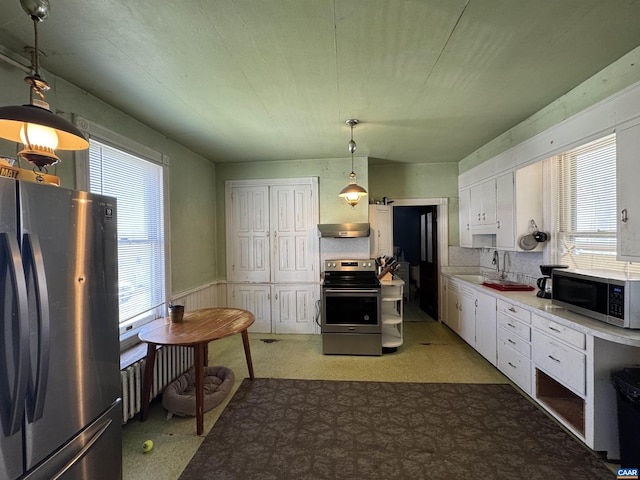 kitchen with white cabinetry, a healthy amount of sunlight, appliances with stainless steel finishes, and under cabinet range hood