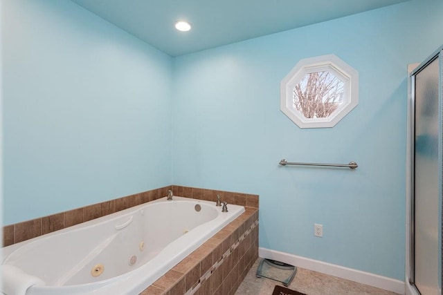 bathroom with a jetted tub, a shower stall, and baseboards