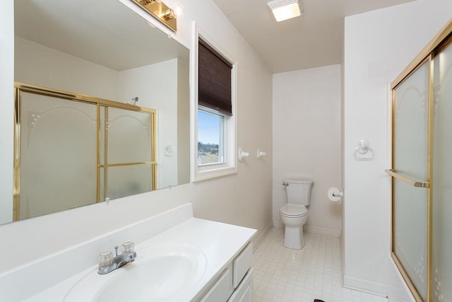 bathroom with toilet, a shower stall, vanity, and baseboards