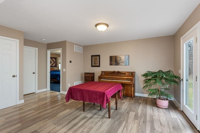 bedroom with visible vents, light wood-style flooring, and baseboards