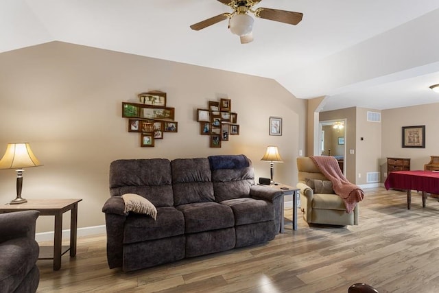 living room featuring lofted ceiling, visible vents, and wood finished floors