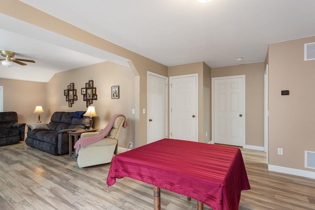 bedroom with light wood-type flooring, visible vents, arched walkways, and baseboards