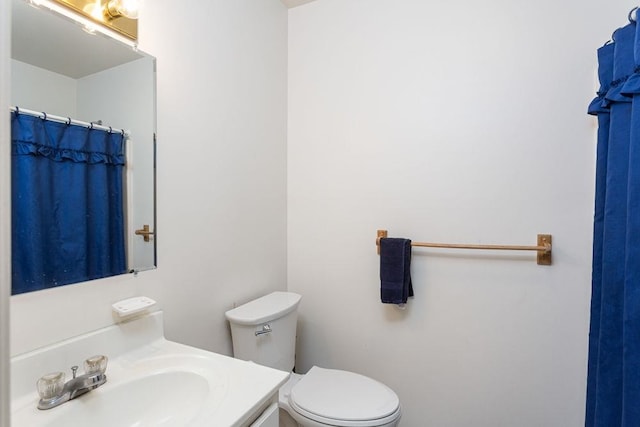 bathroom featuring a shower with curtain, vanity, and toilet