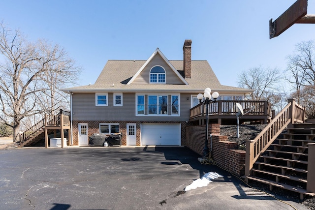 back of house with a garage and a wooden deck