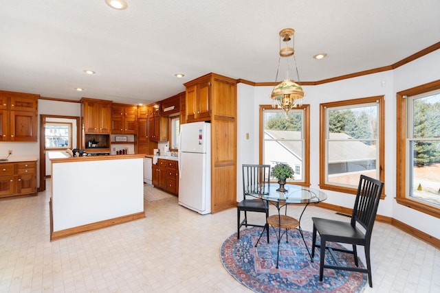 kitchen featuring ornamental molding, white appliances, a chandelier, and decorative light fixtures