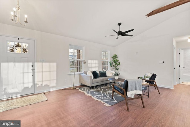 living room with ceiling fan with notable chandelier, lofted ceiling, and hardwood / wood-style floors