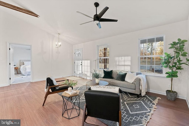 living room featuring hardwood / wood-style flooring, lofted ceiling, and ceiling fan with notable chandelier