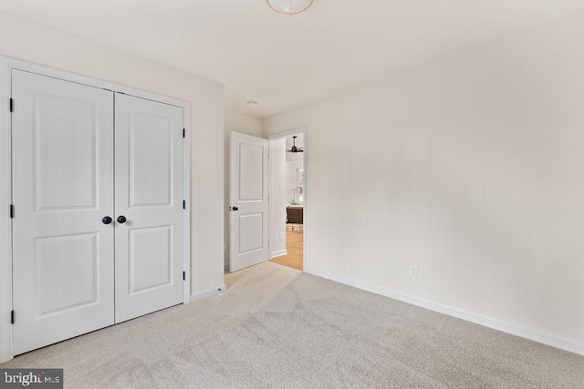 unfurnished bedroom with light carpet and a closet