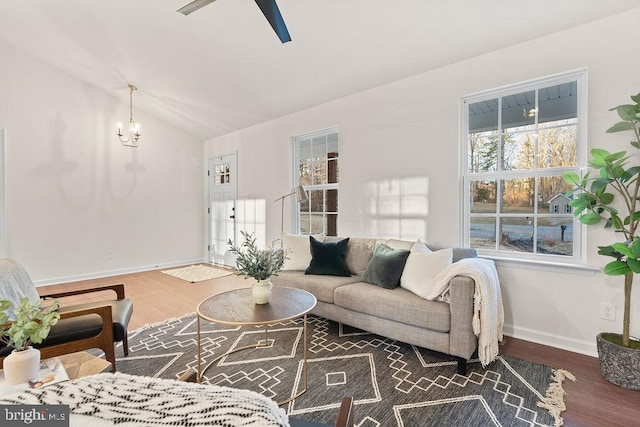 living room with lofted ceiling, dark hardwood / wood-style flooring, and ceiling fan with notable chandelier