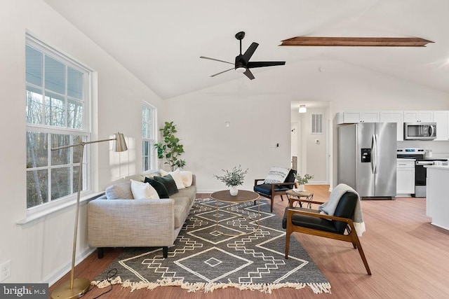 living room featuring wood-type flooring, vaulted ceiling, and ceiling fan