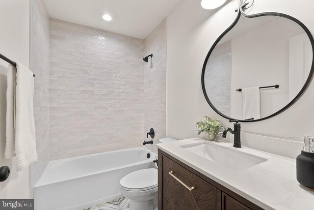 full bathroom with tiled shower / bath combo, vanity, and toilet