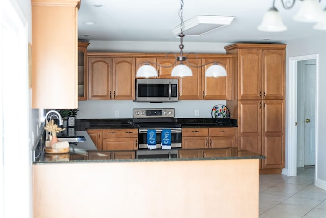 kitchen with pendant lighting, light tile patterned floors, appliances with stainless steel finishes, a sink, and a peninsula