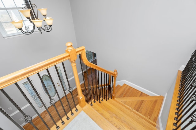 staircase featuring baseboards and wood finished floors