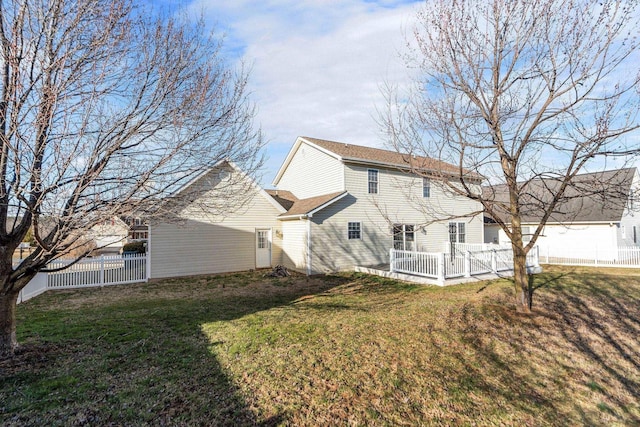 back of property featuring fence and a lawn