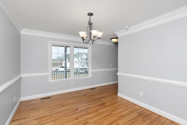 spare room featuring visible vents, crown molding, and wood finished floors