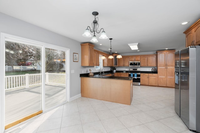 kitchen featuring a notable chandelier, hanging light fixtures, appliances with stainless steel finishes, a sink, and a peninsula