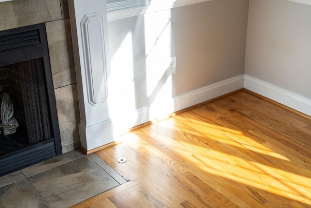 interior space featuring a fireplace, baseboards, and wood finished floors