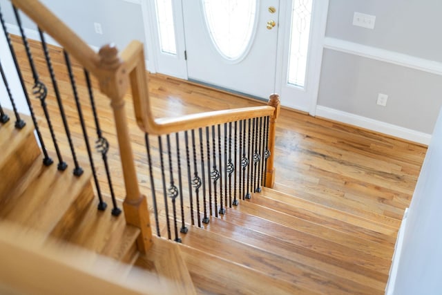 stairs with wood finished floors and baseboards