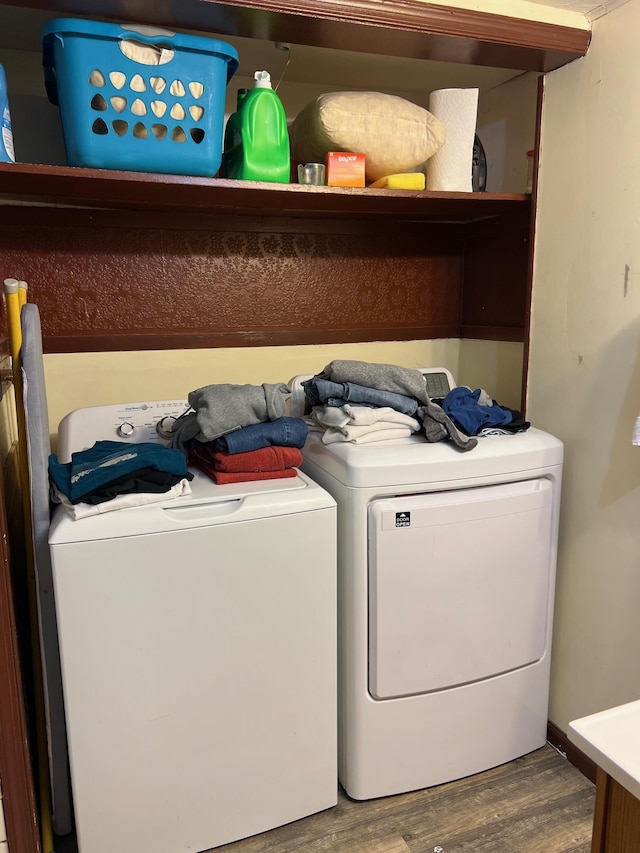 laundry area with wood-type flooring and separate washer and dryer
