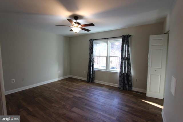 spare room featuring dark wood-type flooring and ceiling fan