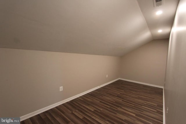 bonus room with dark wood-type flooring and vaulted ceiling