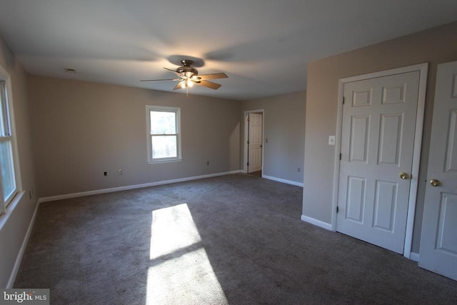 unfurnished room featuring ceiling fan and dark carpet