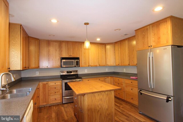 kitchen with stainless steel appliances, dark hardwood / wood-style floors, sink, and a kitchen island