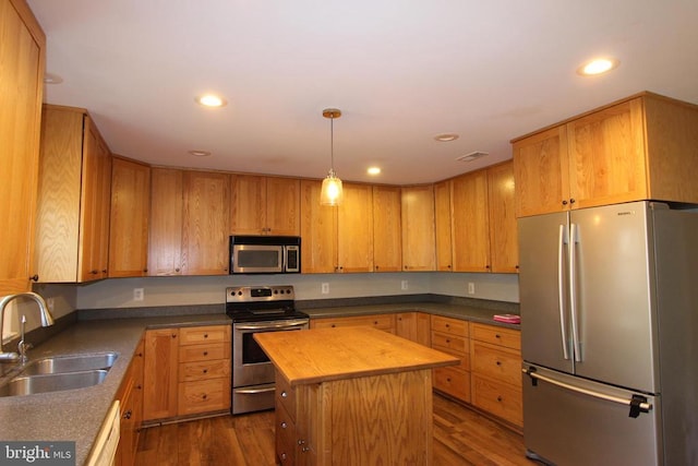 kitchen featuring a kitchen island, appliances with stainless steel finishes, butcher block countertops, sink, and dark wood-type flooring