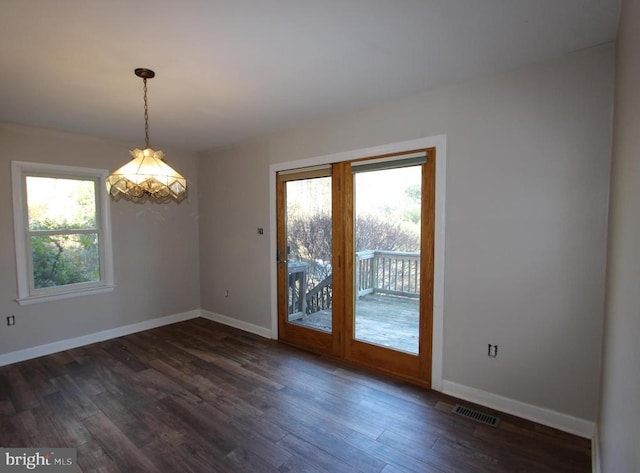 unfurnished room featuring a healthy amount of sunlight and dark hardwood / wood-style floors