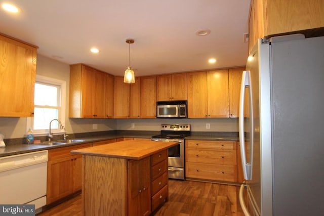 kitchen featuring dark hardwood / wood-style flooring, sink, stainless steel appliances, and a center island