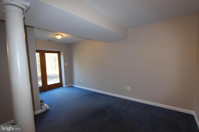 carpeted empty room featuring ornate columns