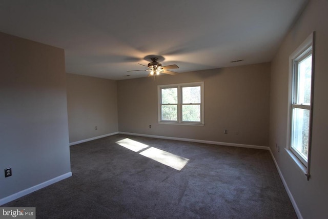 empty room with ceiling fan and dark carpet