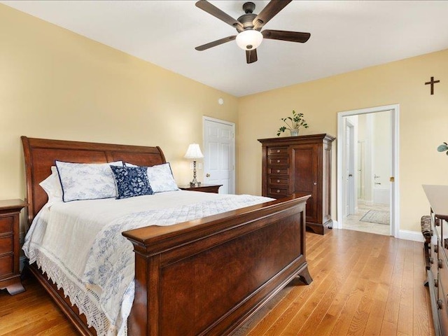 bedroom with ceiling fan, ensuite bathroom, and light wood-type flooring