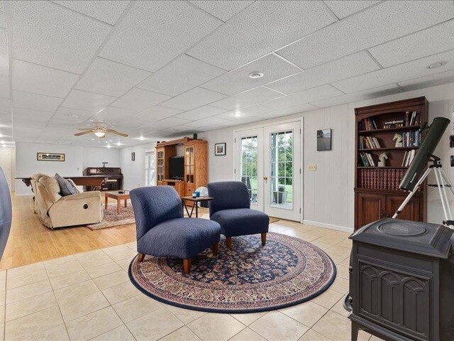 tiled living room featuring french doors and ceiling fan