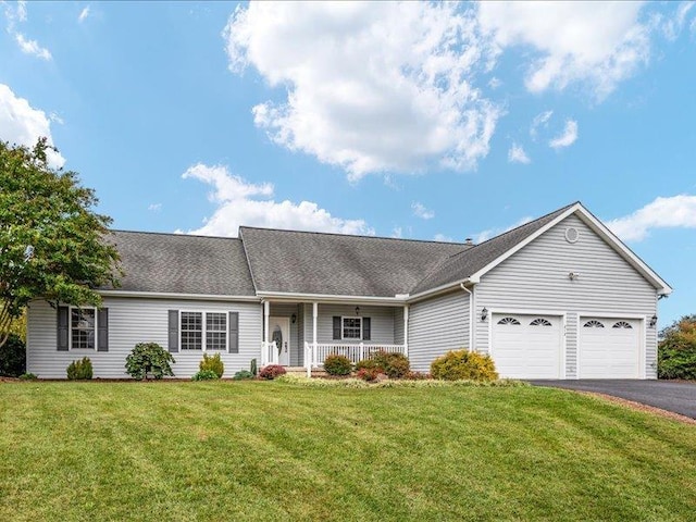 single story home featuring a garage, covered porch, and a front lawn