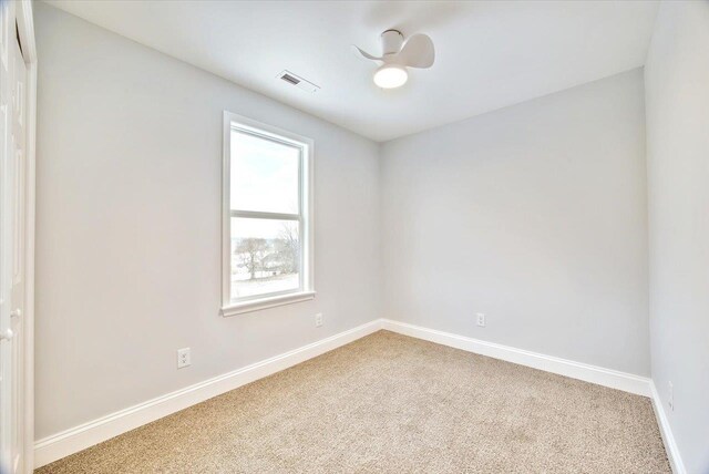 carpeted spare room with ceiling fan