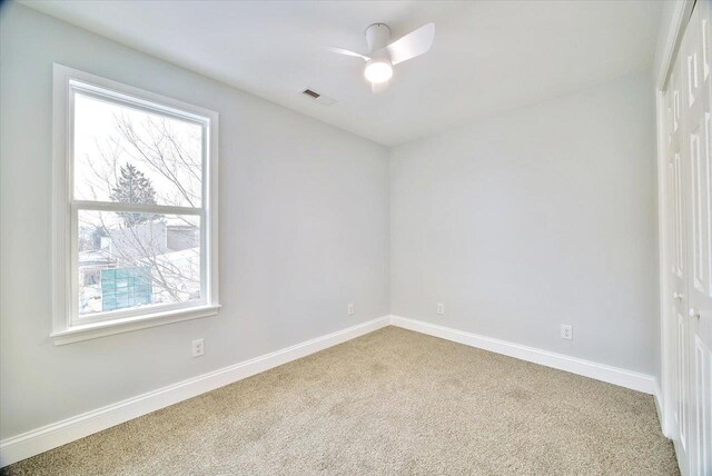 spare room featuring carpet flooring and ceiling fan