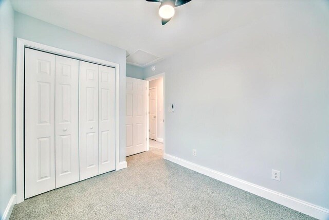 unfurnished bedroom with light carpet, ceiling fan, and a closet