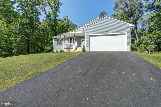 ranch-style home featuring a porch, driveway, a front yard, and a garage