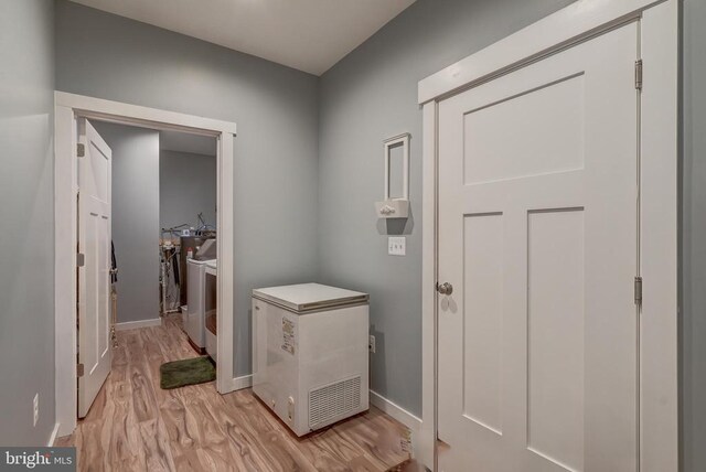 corridor featuring baseboards and light wood finished floors