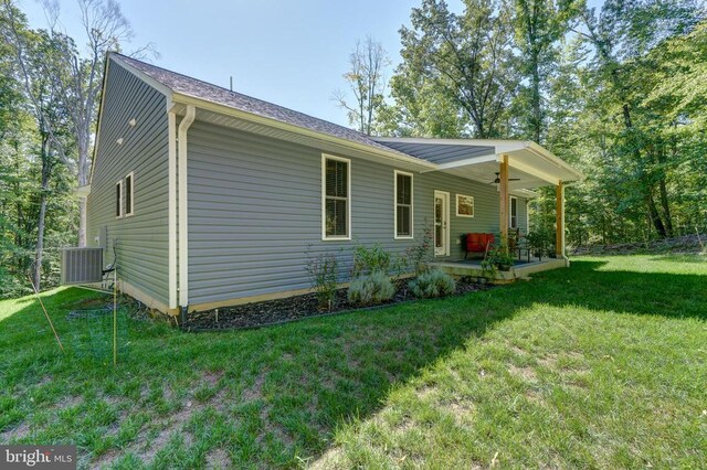 view of side of property with cooling unit, a patio, a lawn, and a ceiling fan