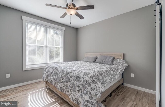 bedroom featuring a ceiling fan, wood finished floors, and baseboards